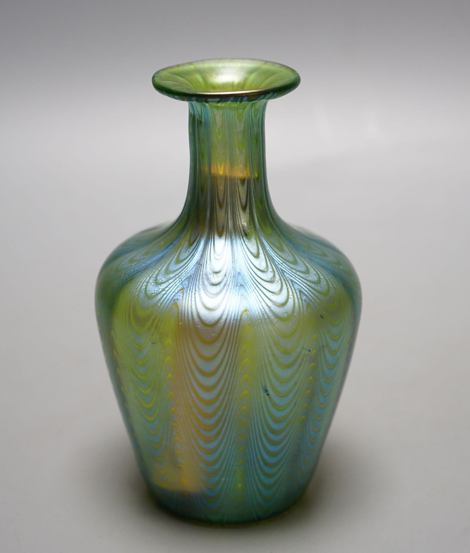 A Loetz style iridescent glass vase, flared narrow neck and bulbous body waved decoration, 14 cms high.